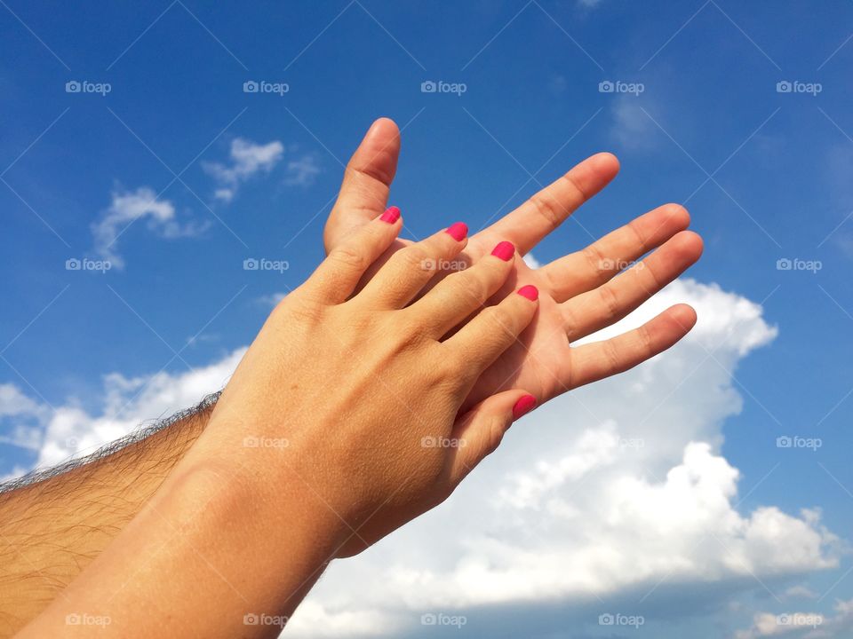 Her hand against his hand towards the sky