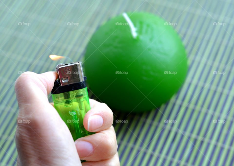 A human holding green cigarette lighter