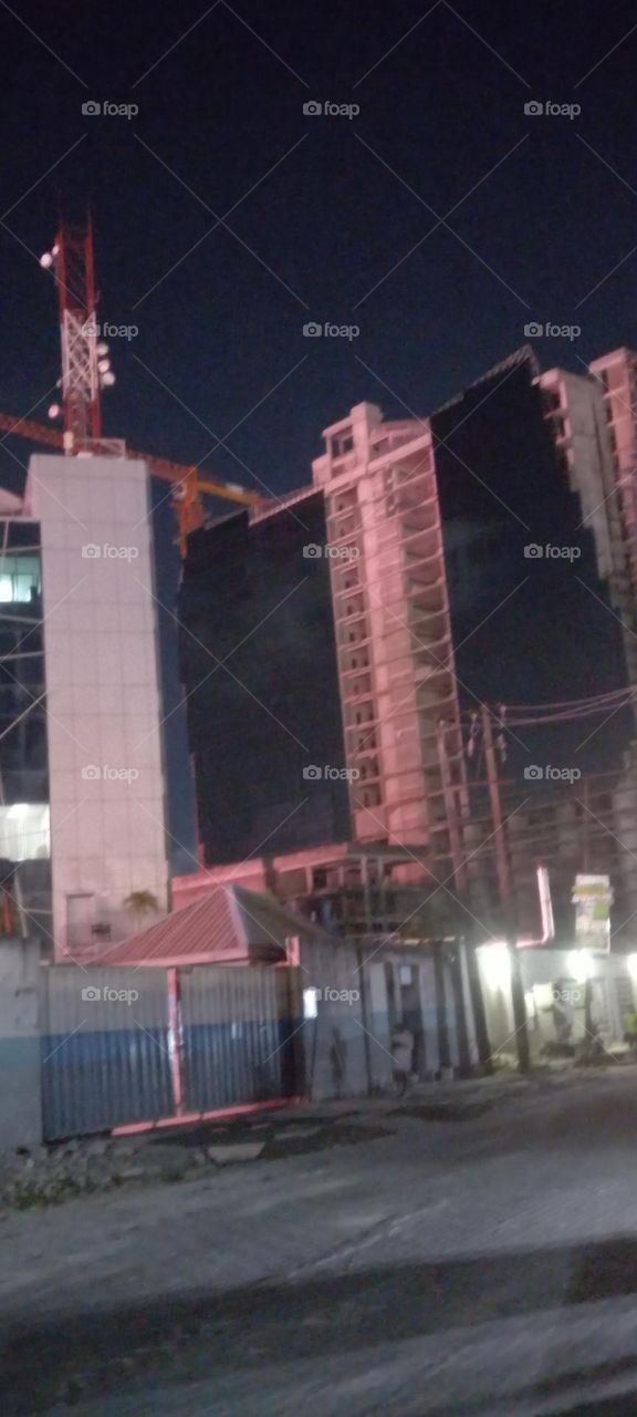 urban high-rise office  building still under construction. Beautiful night  view of building. Well lit.