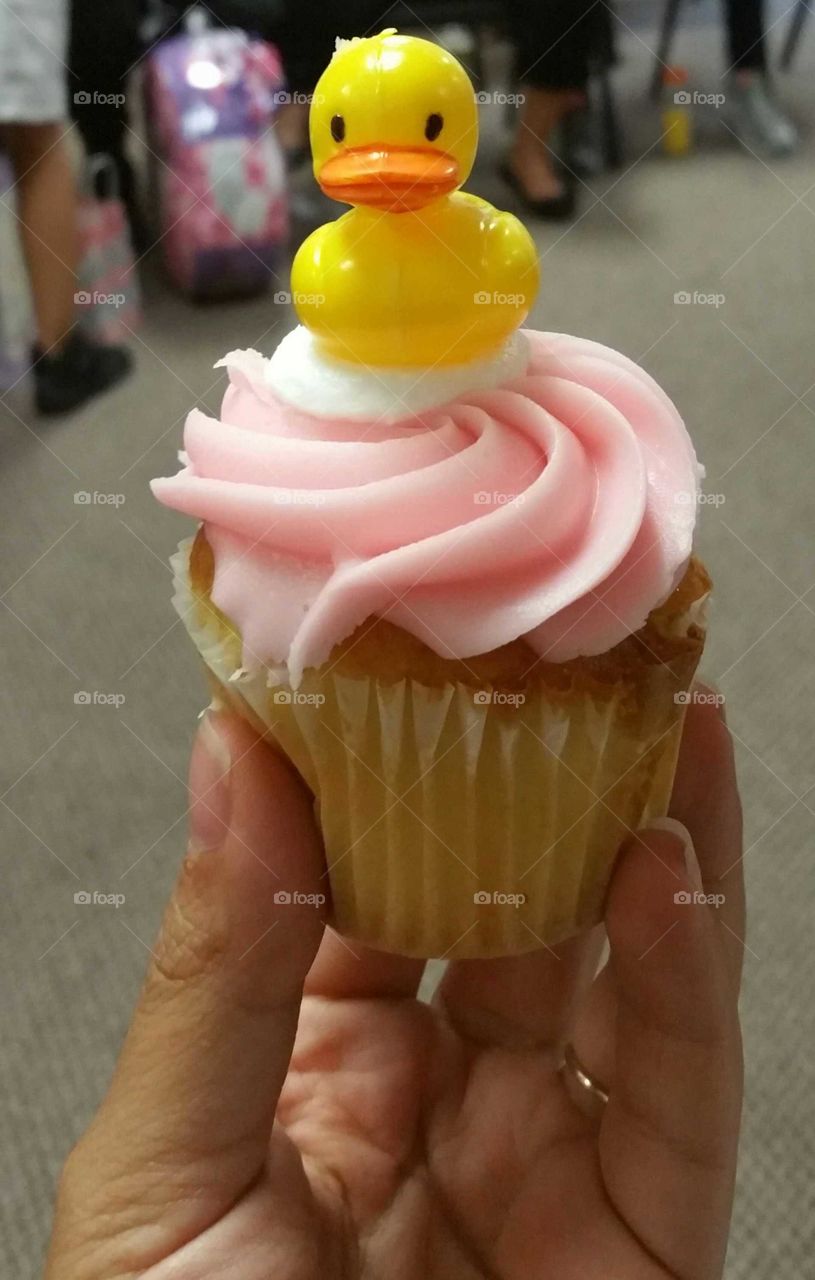 Vanilla cupcake with pink icing and cute duck on top