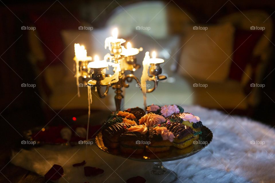 Melting candles and sweets in front of a Victorian couch at night
