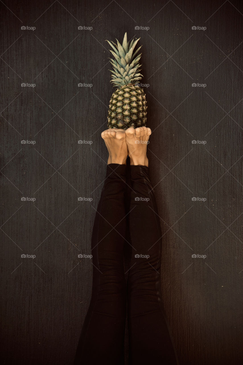 beautiful girl posing on camera with pineapple in her hands