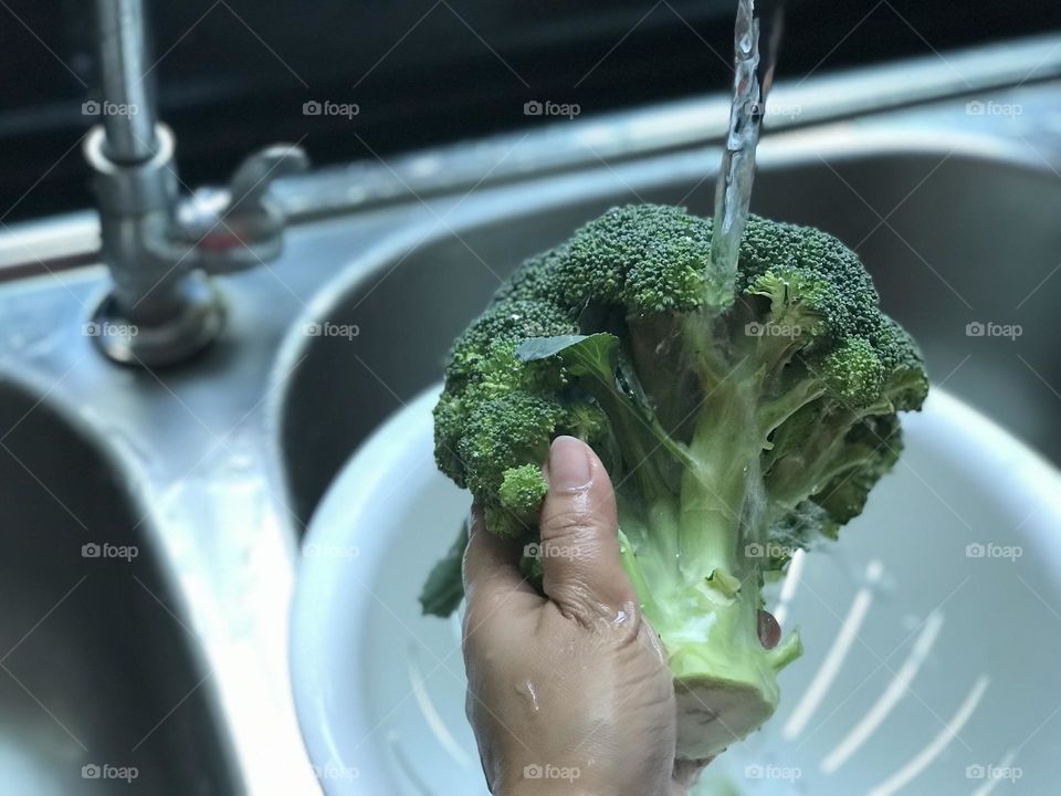 Cleaning broccoli under running water 💦