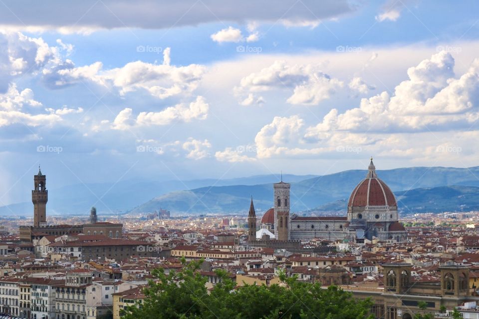 Cidade de Florença, capital da Toscana, com cúpula de Duomo de Firenze evidenciada, em meio a lindo céu azul e montanhas ao fundo 