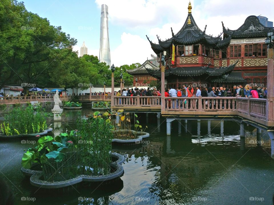 Shanghai Old Town. Entrance for the Mandarin Yu Garden. Can notice a contrast between modern and ancient architecture. In the background is growing the new skyscrape of PuDong: the Shanghai Tower, 2017.