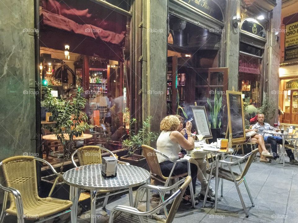 Woman sitting and smoking at a outdoors cafe