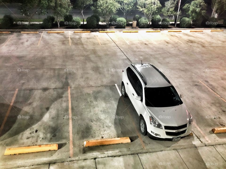 SUV in empty parking area at night 