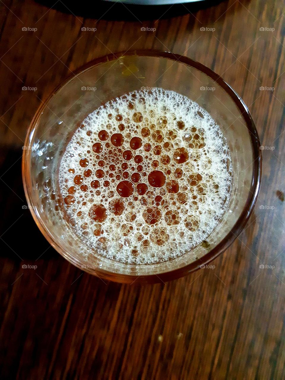 Description: A traditional Moroccan tea cup, elegantly designed with intricate gold patterns, filled with freshly brewed mint tea. The vibrant green tea is served in a small glass cup, reflecting the rich culture and hospitality of Morocco. I