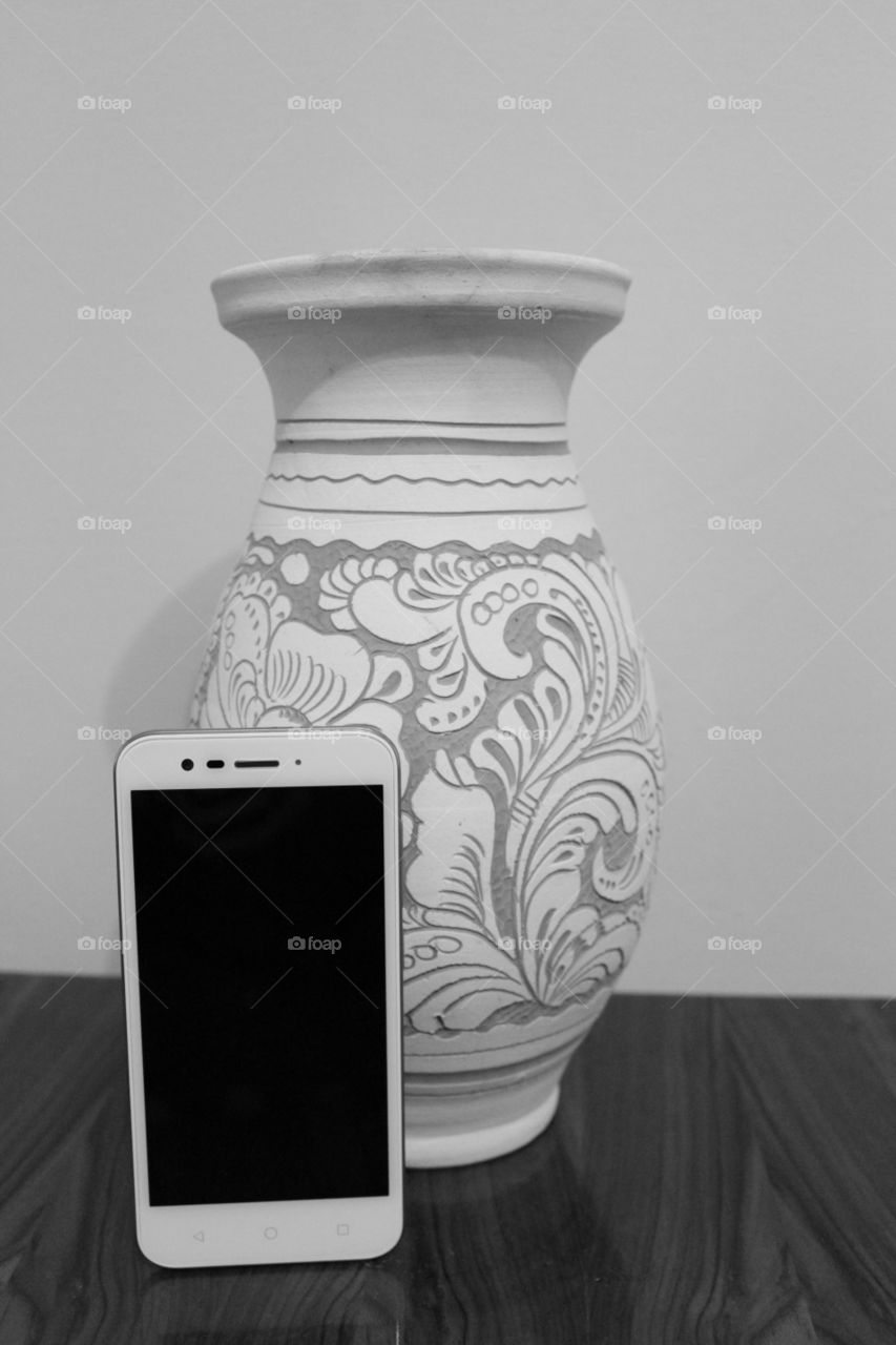 Mobil phone and old vase