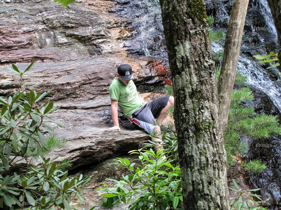 Navigating Rocks Beside Waterfall