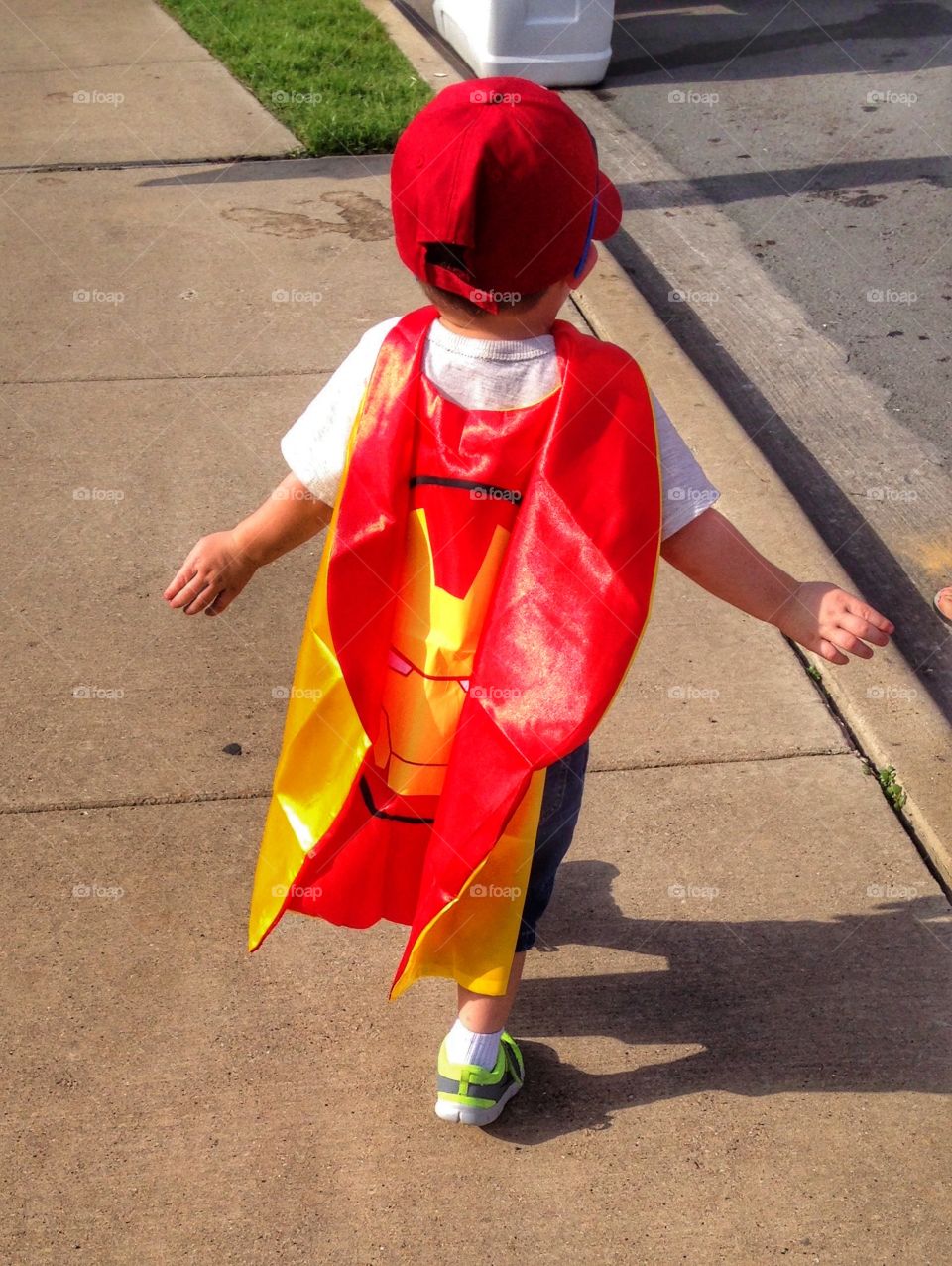 This cape makes me fly. Boy wearing iron man cape