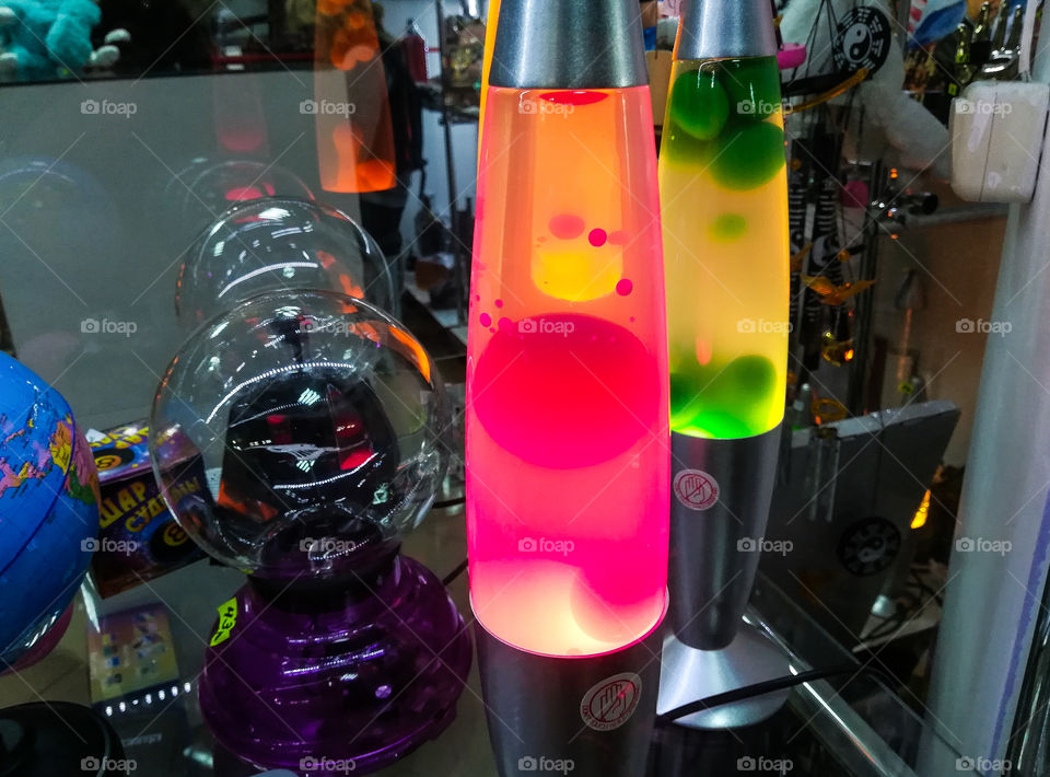 Red and green lava lamps with plasma lamps in the shop; different decorative stuff on the background