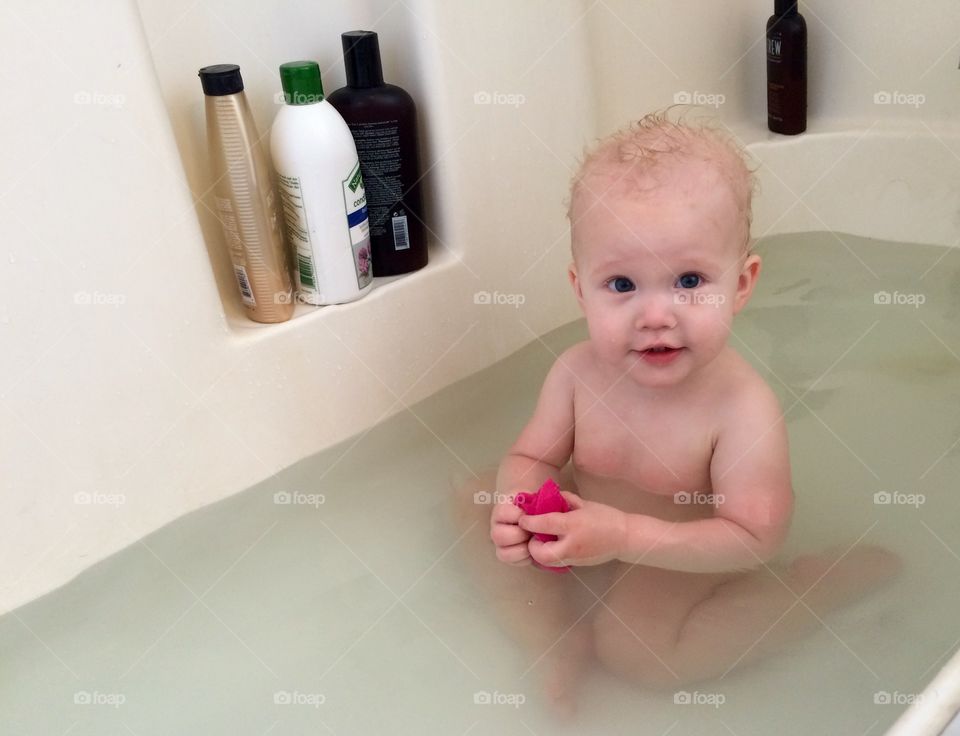 Happy Bathtime Baby. Happy baby girl taking a bath. 