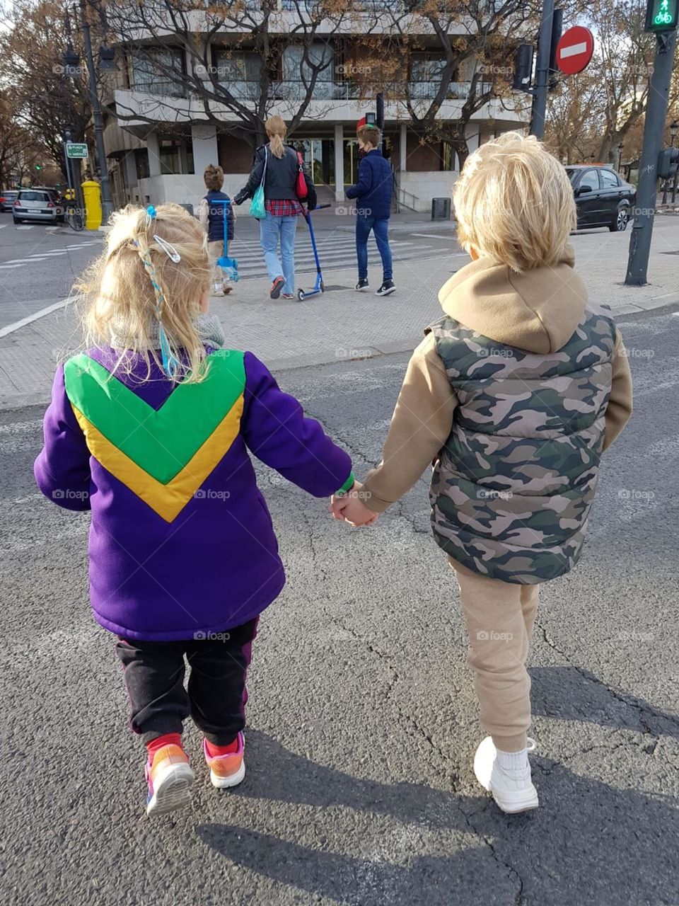 little girl holding boy's hand