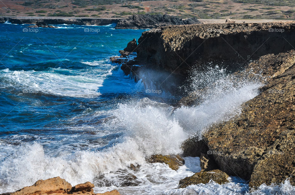 Water splashes on the beach and coast with rocks 