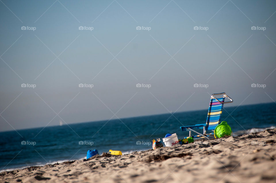 A loan beach chair beach toys and a happy meal on the beach in