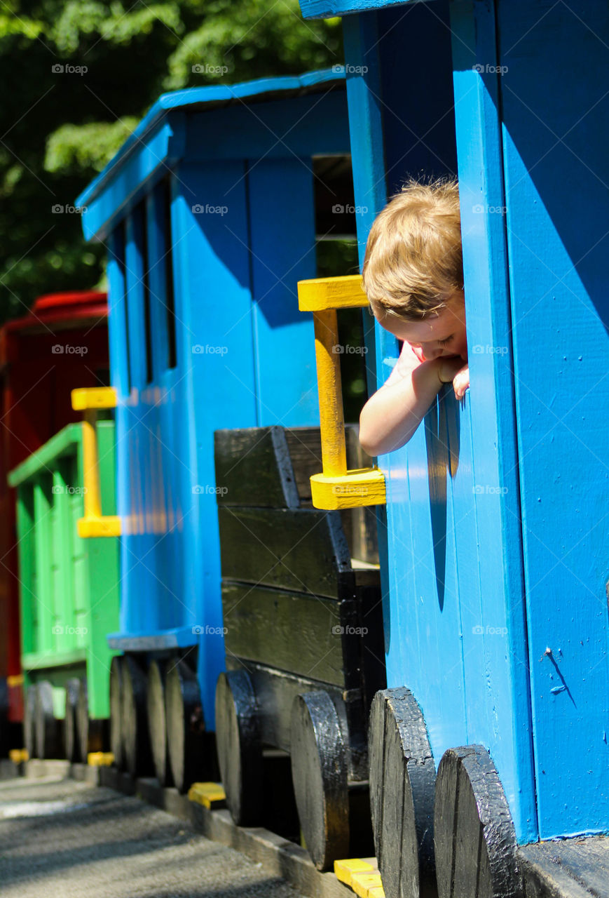 A young boy checks out a playground train