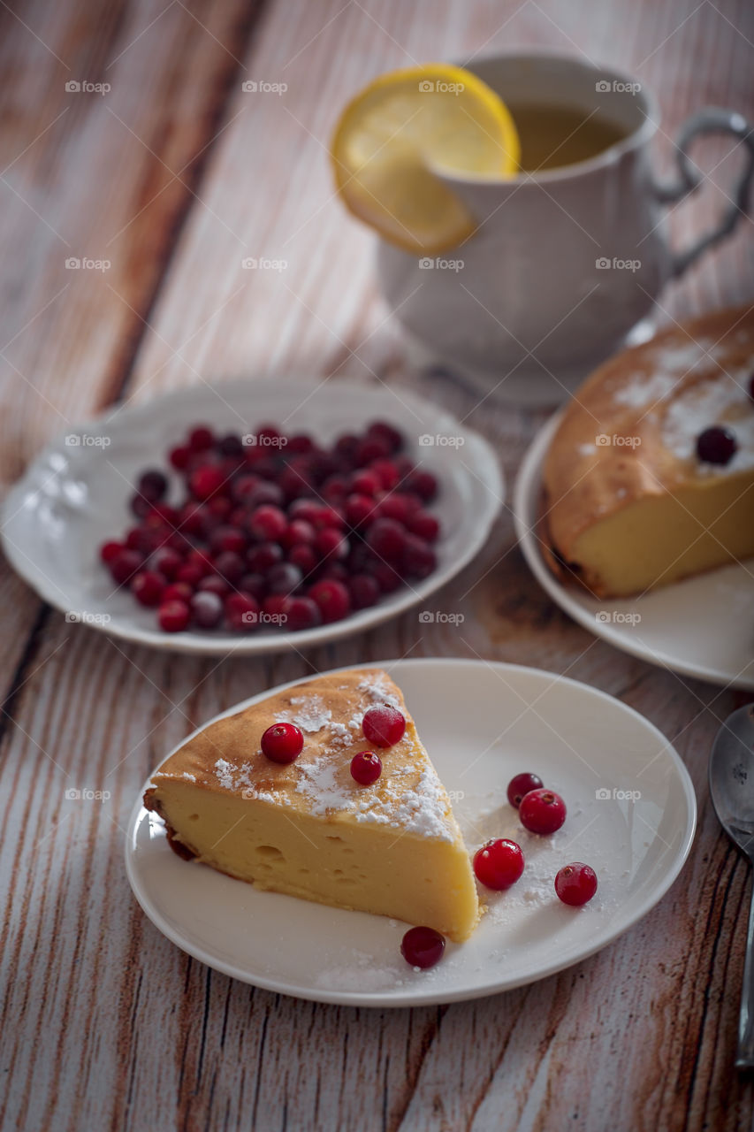 Cheesecake with cranberries and sugar on wooden background 