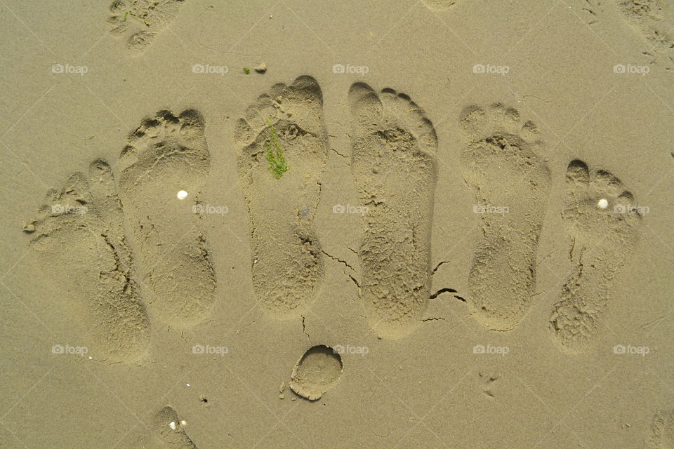 3 peoples feet in the sant.. Putting our fougt in the sant.