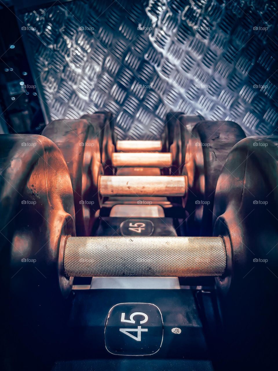 Dumbbells rack in a gym. Light effect gives a feeling of heat and intensity.