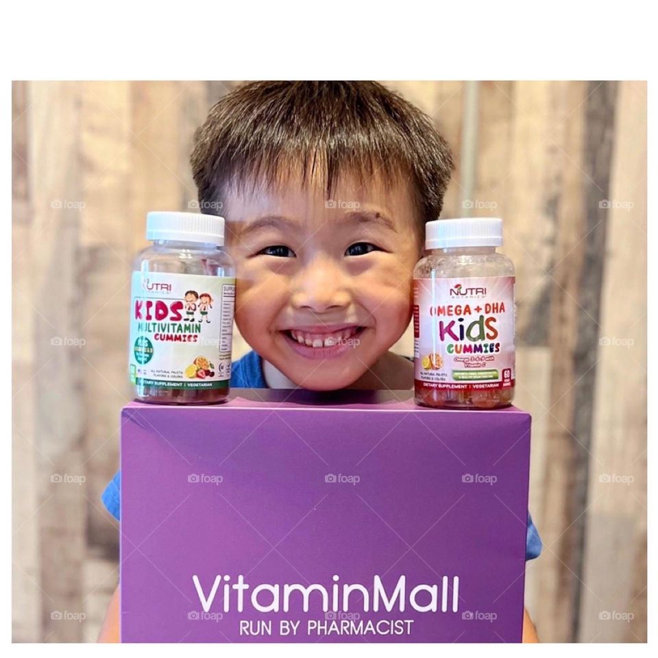 Happy asian kid with multivitamins gummies