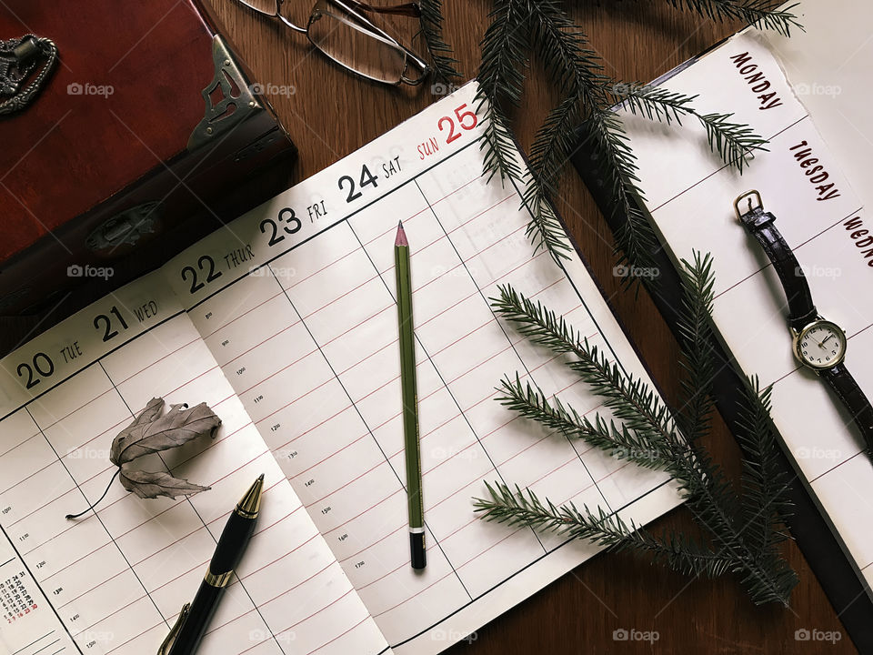 Planner and office supplies on wooden table 