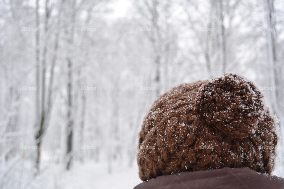 woman in warm hat in the snowy park winter time