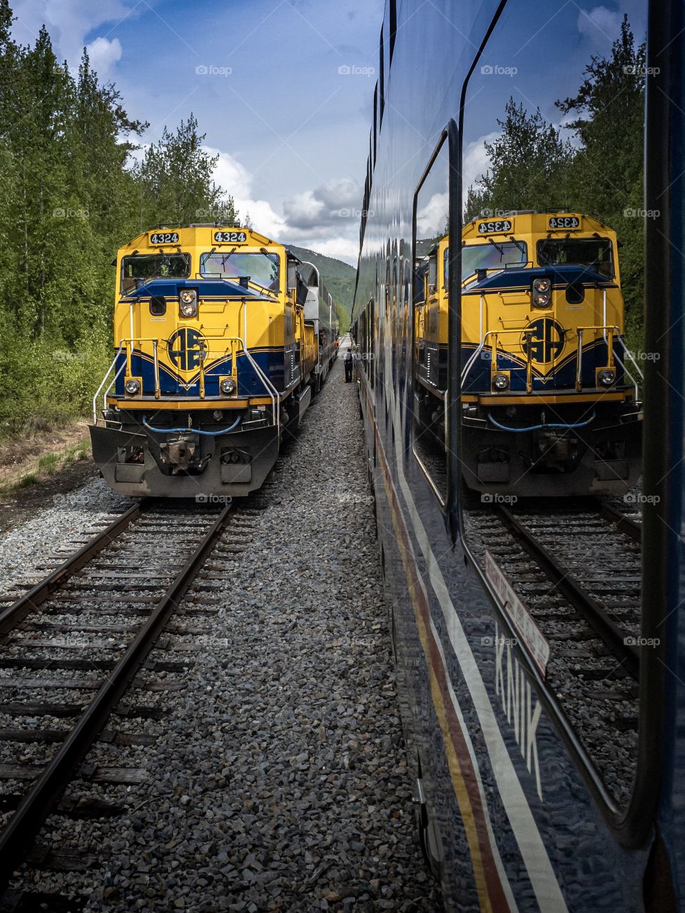 A conductor greets a passing train on the Alaska Railroad 