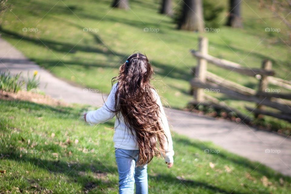 Girl with long gorgeous hair is running outdoors