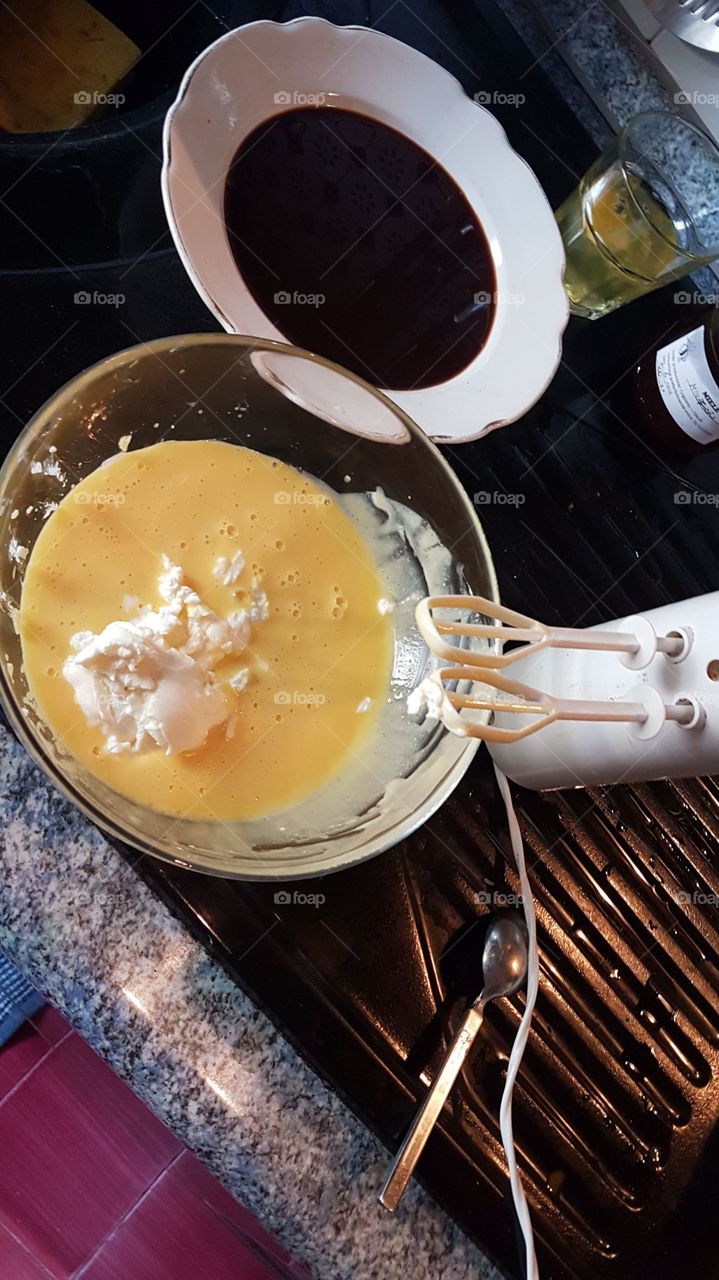 Whips the eggs and mascarpone with the electric whisk