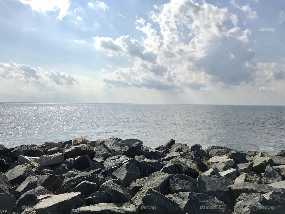 Glimmering sun across The Chesapeake Bay, at Tilghman Island, Maryland. Rain falls on the bay from heavy clouds. 