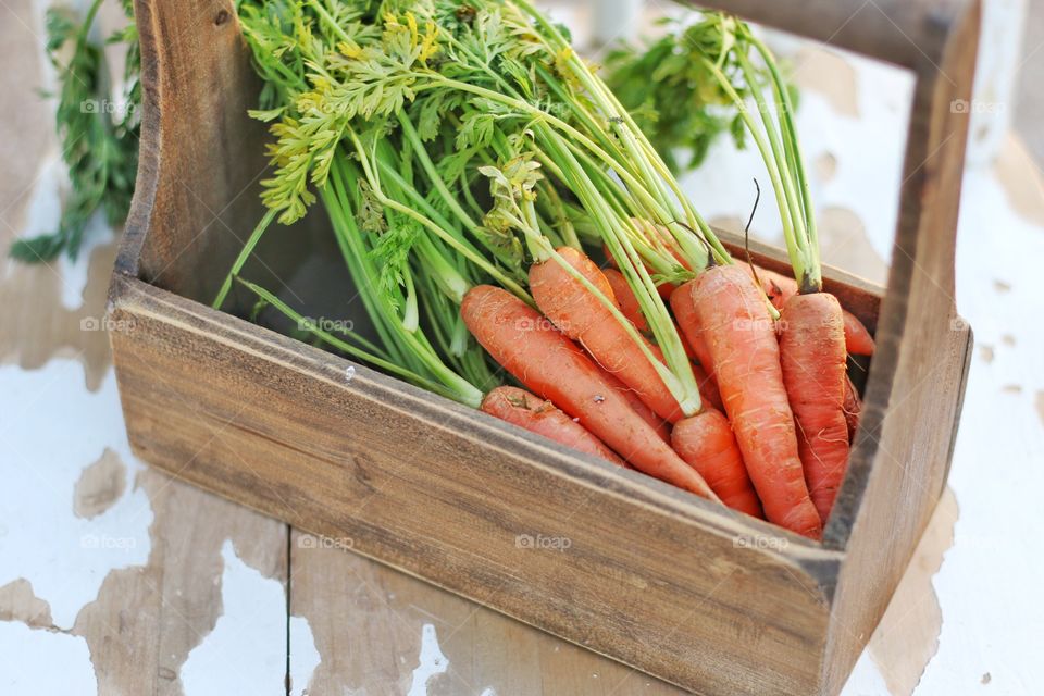 Carrots in wooden basket on table