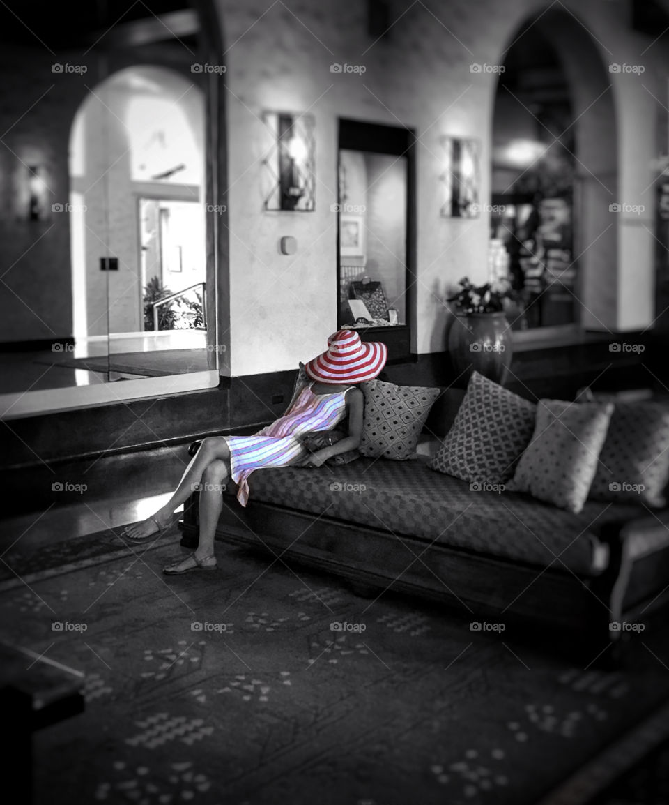 A tired woman tourist asleep on a couch in a hotel lobby