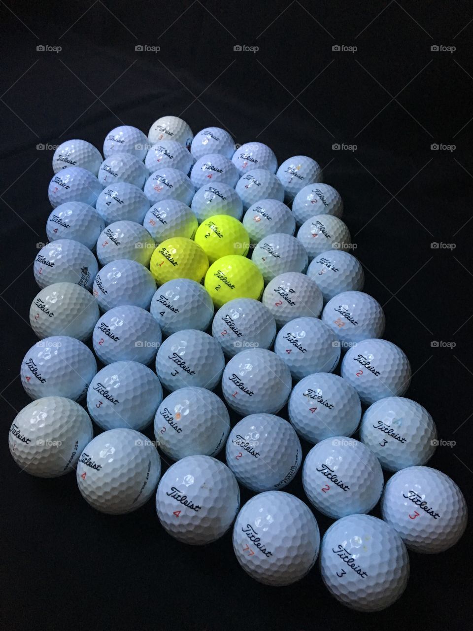 Golf balls, used. Bright yellow and bright white close up. 