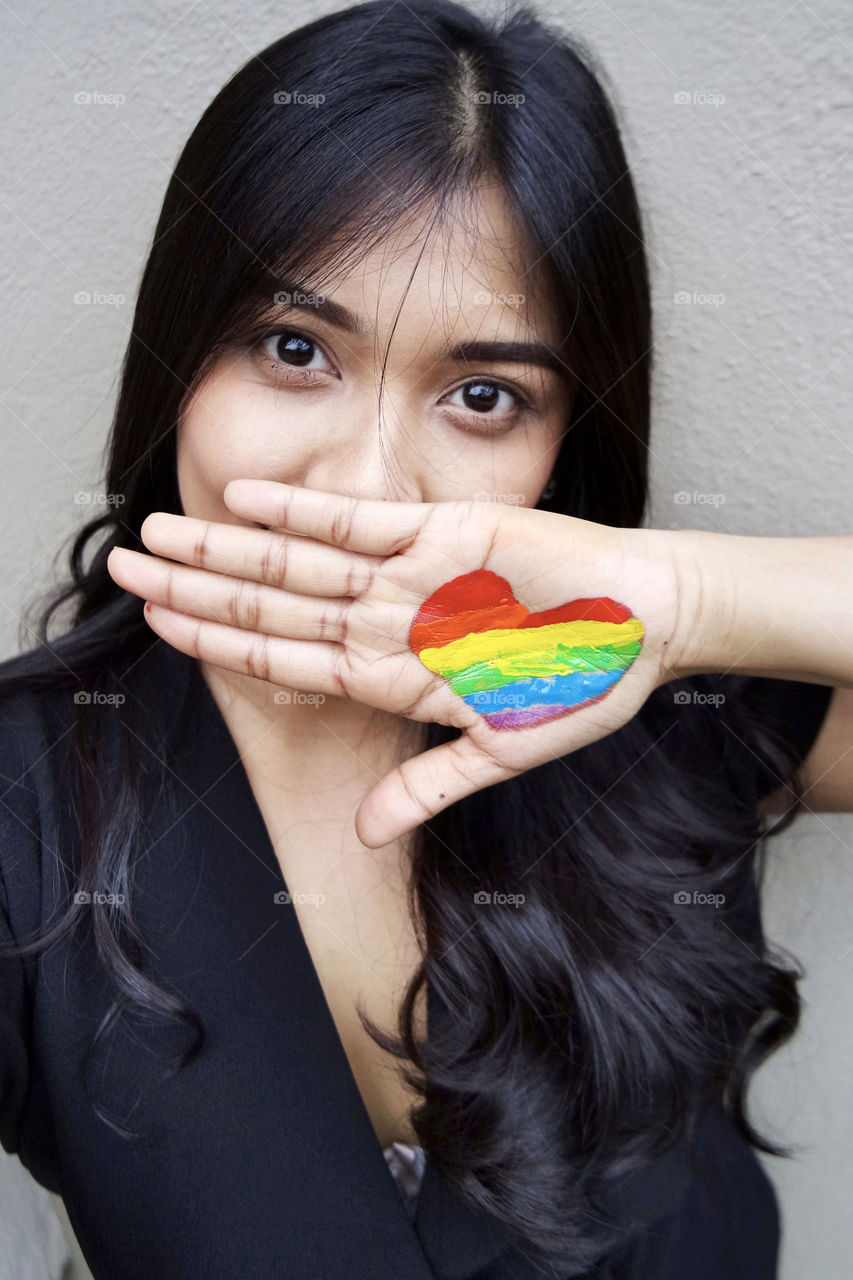 Women with painted rainbow heart 