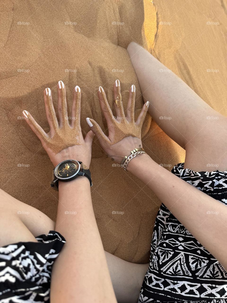 Playful hands that dance in the desert sands and feel cool in the hot desert heat
