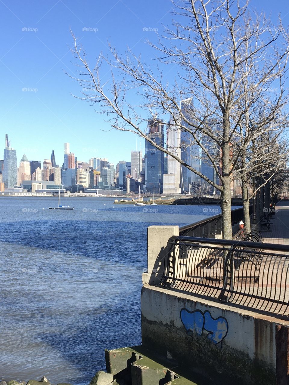 Two hearts graffiti at waterfront with NYC skyline in background
