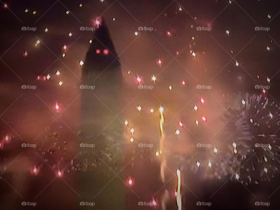 Smokey orange fireworks lighting the night sky.