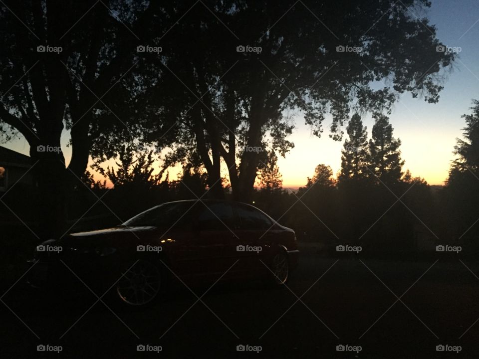 Sports car at sunset. Silhouette of sports car on a hill at sunset