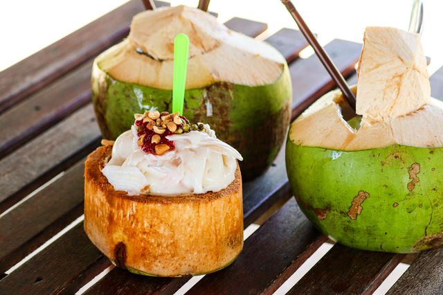 Coconut ice cream on a wooden table by the beach