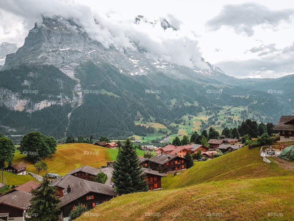 The beautiful and mighty mountain Eiger, shrouded in mist and clouds rises above the wonderful place of Grindelwald.
