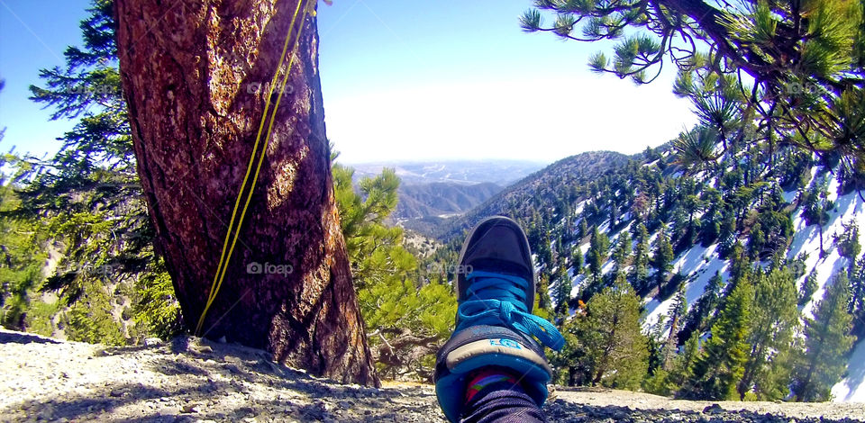 Foot hanging at the mountain cliff