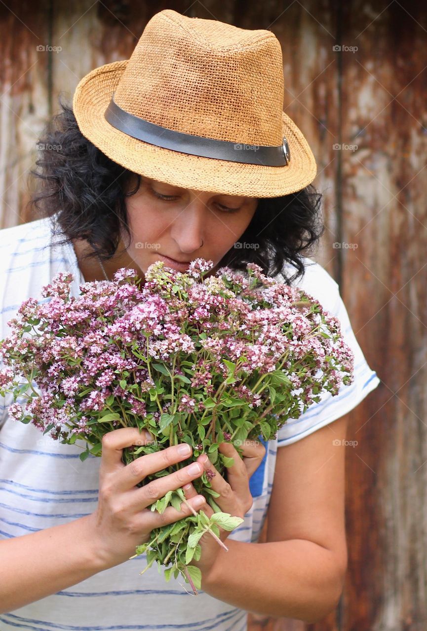 Woman smells oregano herbs