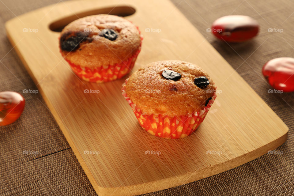 Sweet cup cake muffins on a wooden board