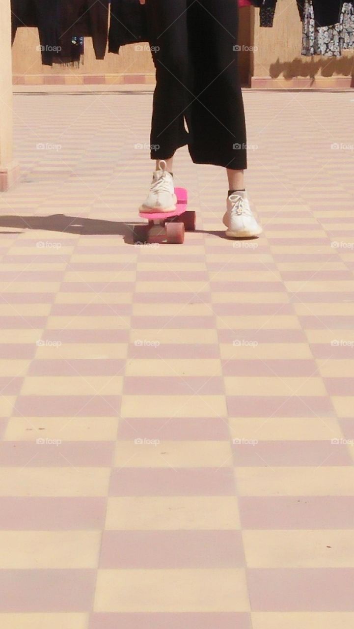 Young girl playing by skate board.