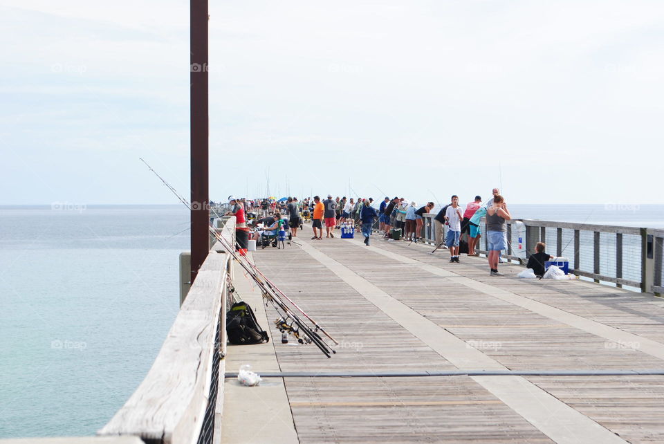 Many people fishing at the pier