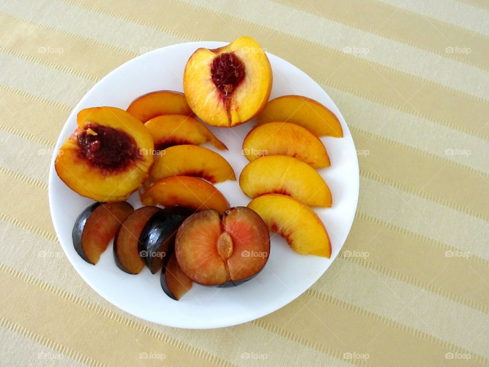 Halved and sliced plum, nectarine and peach