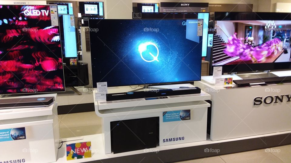 Samsung QLED television 4K Ultra High Definition TV with soundbar and sub-woofer on plinth