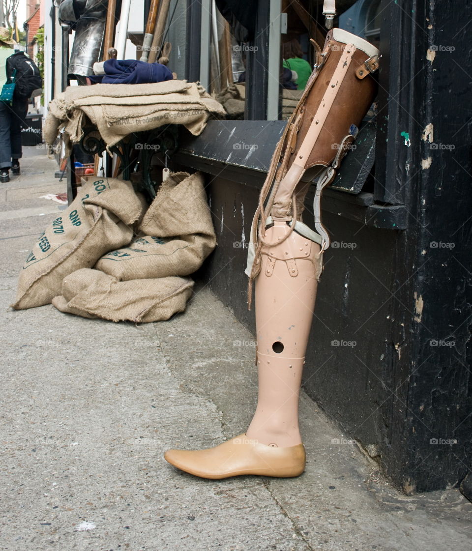 A used and older prosthetic leg sits outside a junk shop in Hastings Old Town