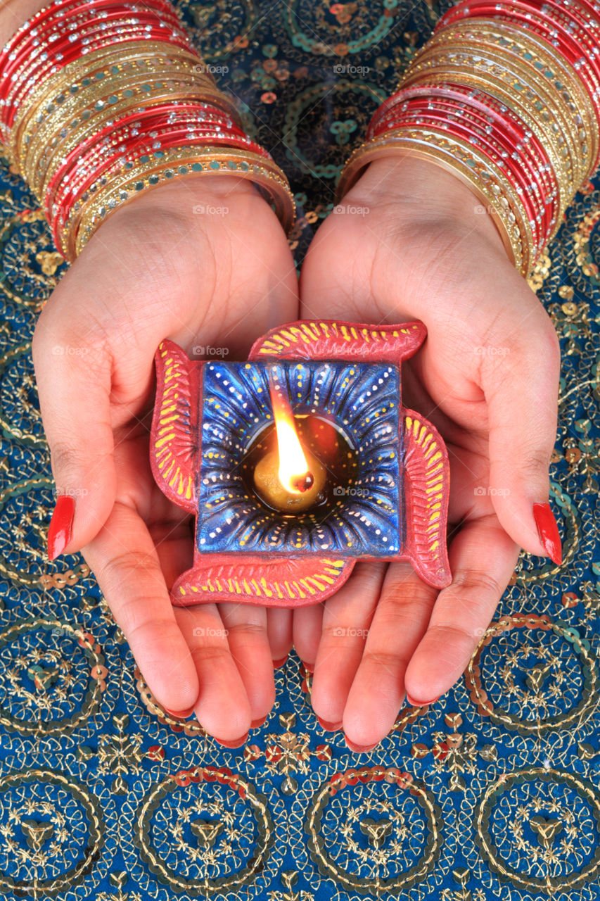 Handmade Diwali diya Indian clay lamp in female hands